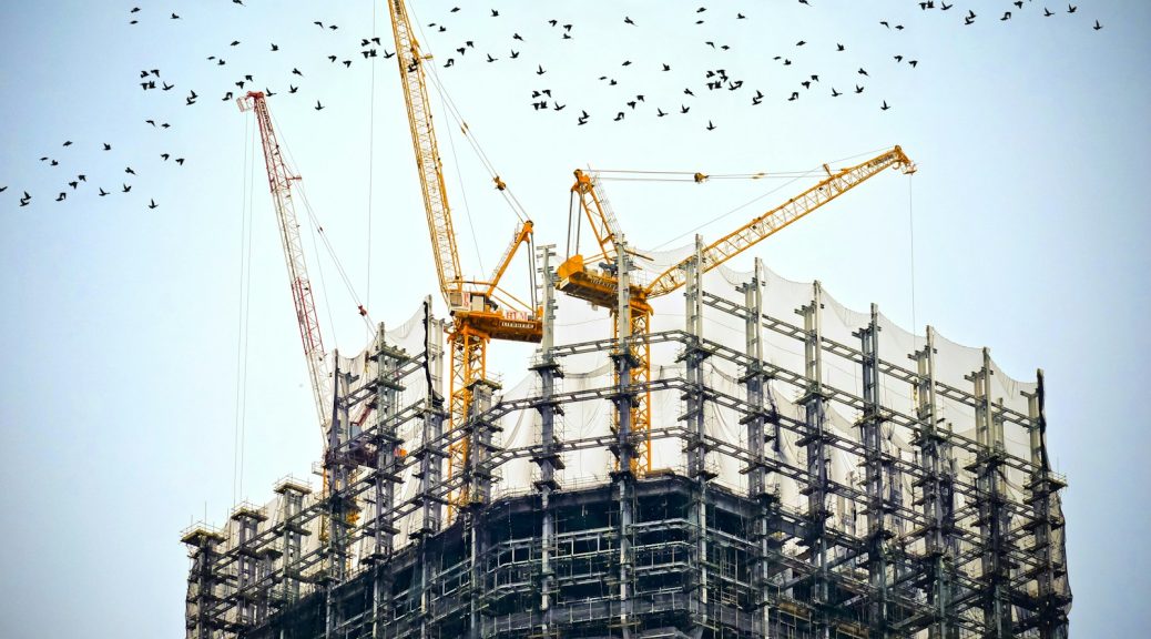 low angle photography of cranes on top of building